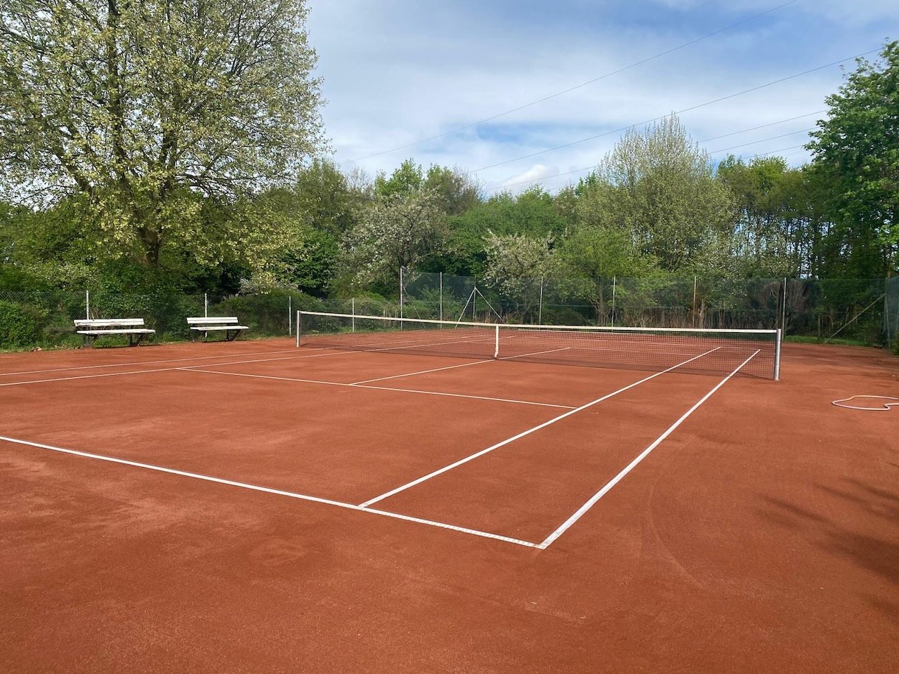 Frisch instand gesetzter Sandplatz mit weißen Linien und Netz